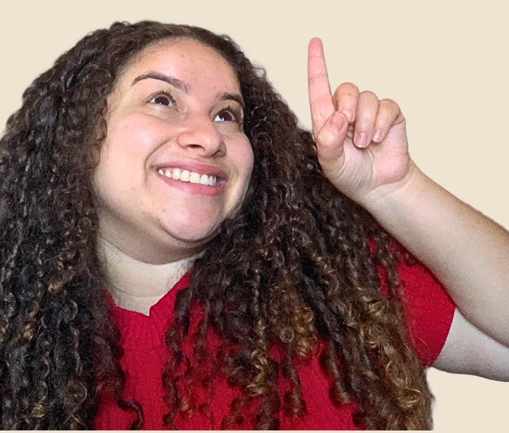 Professora Raquel sorrindo e apontando para cima